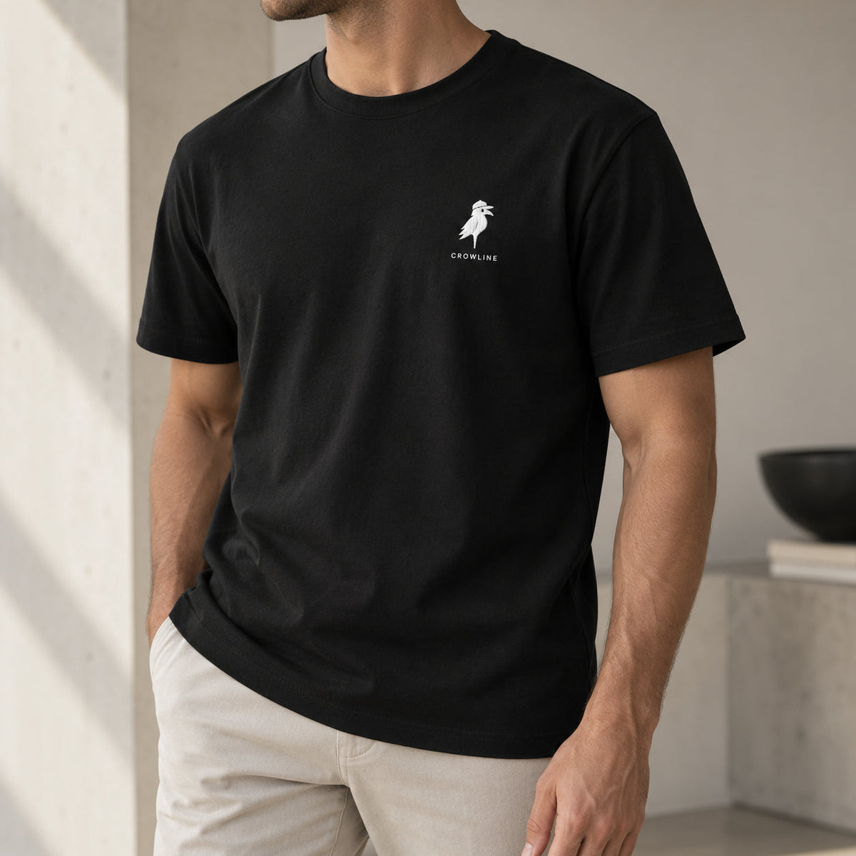 Crow Tee in Black — worn, chest logo detail